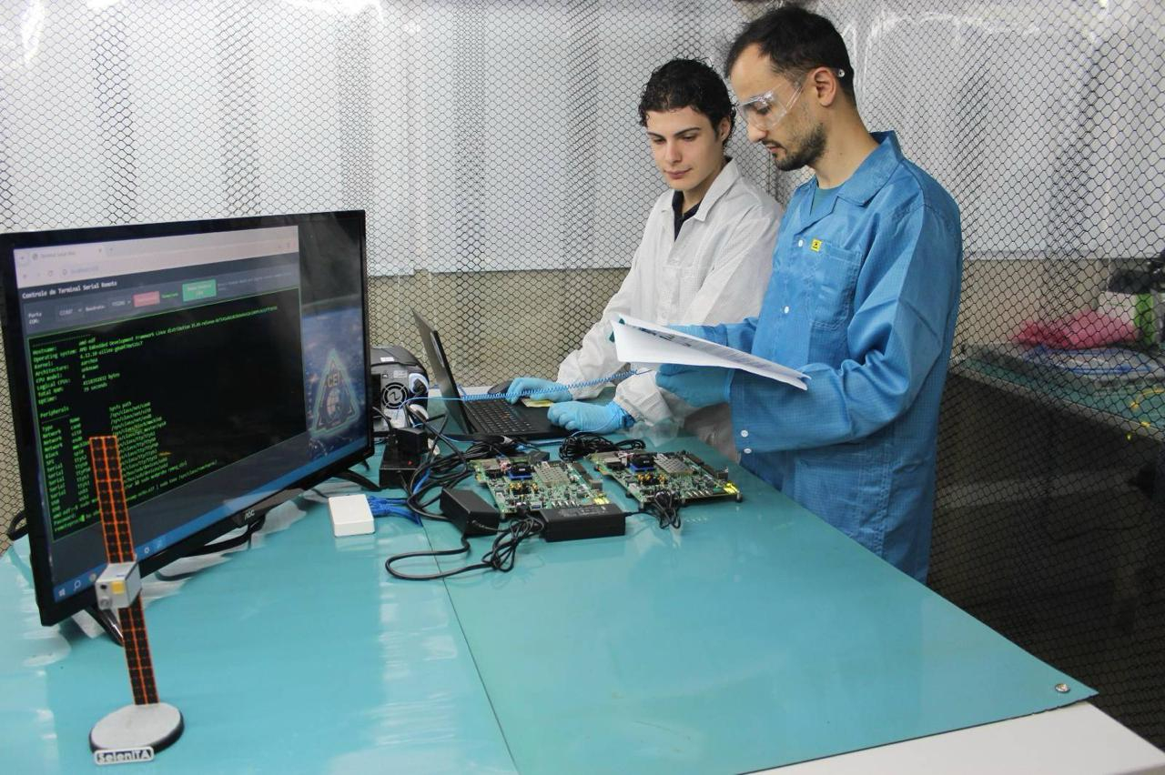 Vitor Cruz e Felipe Tralli na bancada de desenvolvimento de software da missão SelenITA (crédito: Agência Espacial Brasileira)